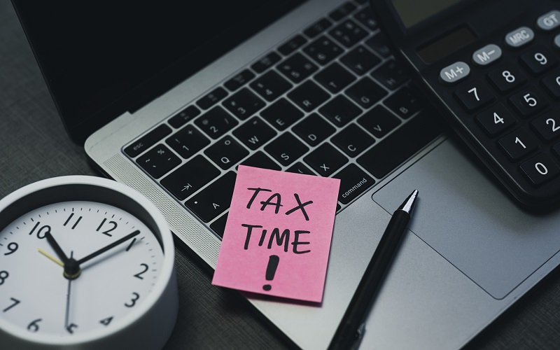 Laptop that says tax time on sticky note